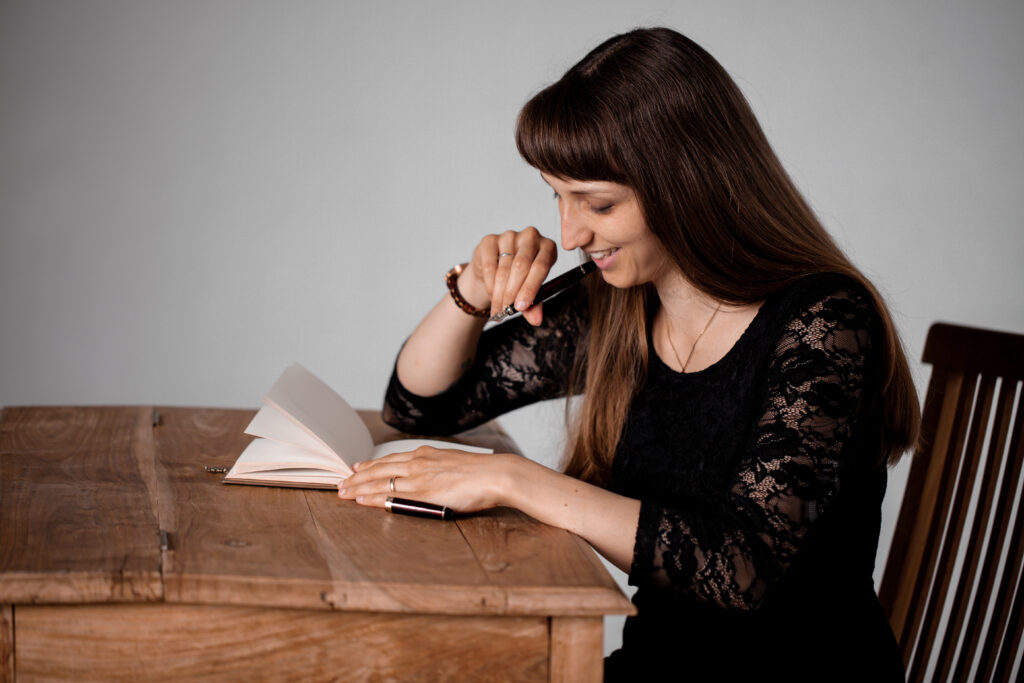 Frau mit Notizbuch an antikem Schreibtisch